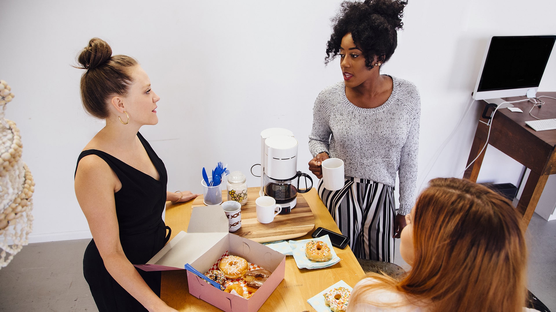 Colleagues enjoying donuts in breakroom
